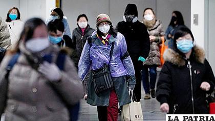 Las personas usan máscaras faciales dentro de una estación de metro para protegerse del brote del nuevo coronavirus / REUTER