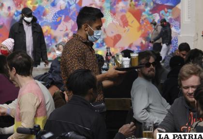 Un mesero atiende a comensales en una cafetería de Bruselas /AP Foto /Olivier Matthys, File