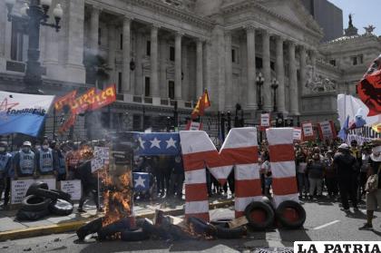Letras que forman la sigla del Fondo Monetario Internacional se incendian durante una protesta frente al Congreso /AP Foto /Rodrigo Abd