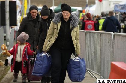 Una niña mira su muñeco de felpa mientras camina junto a otros refugiados ucranianos /AP Foto /Sergei Grits
