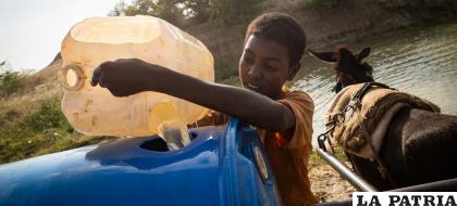 Un niño recoge agua de una cuenca rehabilitada en el estado meridional sudanés Nilo Blanco / PNUMA
