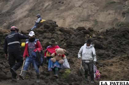 Residentes caminan en un área barrida por un deslizamiento de tierra en Alausí /AP