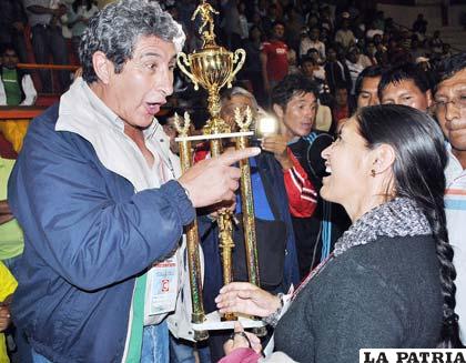 <b>SATISFACCIÓN GENERAL:</b> El presidente de la Febolfusa Juán Gironás entrega el trofeo de campeón nacional de la Dimafusa a la señora Inés Humacayo, presidente del club Laboratorio Químico VHSR. Las expresiones en los rostros de ambos dirigentes demuestra que hubo satisfacción general.