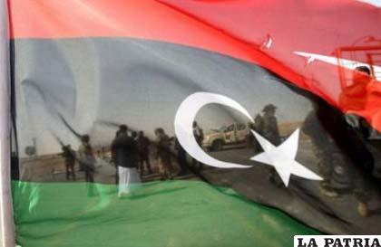 Rebeldes libios vistos a través de su bandera en la puerta Oeste de la ciudad de Adjabiyá