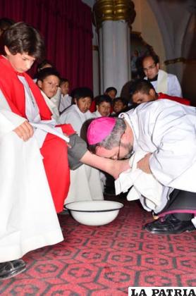 El obispo Bialasik imita la actitud humilde de Jesús, lavando y besando los pies de los monaguillos