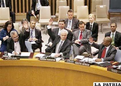 En la imagen, (de I-D) el embajador portugués en Naciones Unidas, Jose Filipe Moraes Cabral; el embajador ruso, Vitaly Churkin, y el de Sudáfrica, Baso Sangqu votan durante la reunión del Consejo de Seguridad de la ONU en Nueva York
