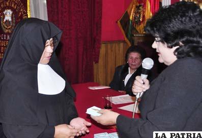 Virginia Rocabado entrega la condecoración a la religiosa representante del Asilo de Ancianos