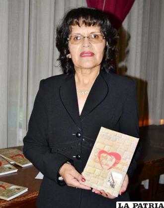 La escritora Milena Montaño sostiene una copia de su novela