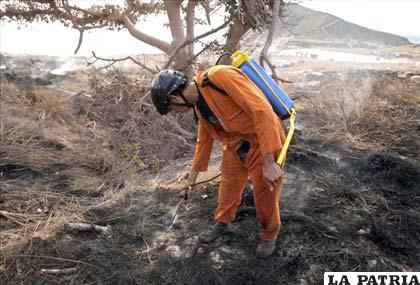 Un miembro del cuerpo de bomberos de Nicaragua apaga el fuego durante las labores de monitoreo del volcán Santiago de Masaya