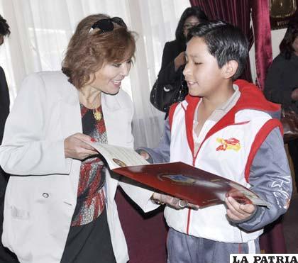 Viviana Garrón entrega el reconocimiento a uno de los niños galardonados