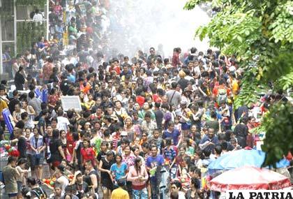 Cientos de turistas y tailandeses celebran la fiesta del agua en la calle Silom en el centro económico de Bangkok (Tailandia) durante el Festival Songkran