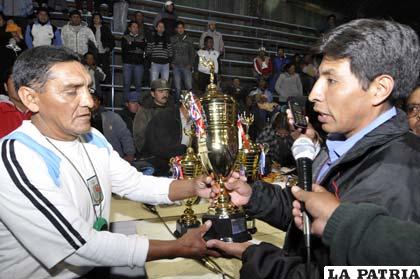 El delegado de Cochabamba recibe el trofeo de campeón