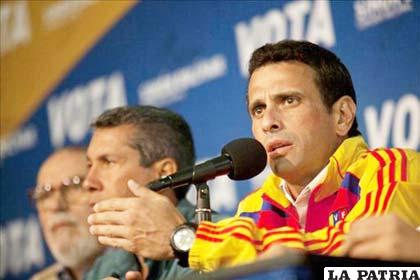 El candidato presidencial opositor de Venezuela, Henrique Capriles (d), habla junto jefe del Comando Simón Bolívar, Henri Falcón (c)
