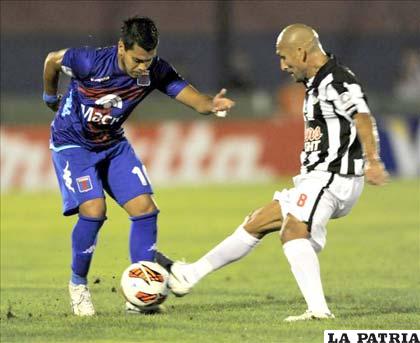 Pérez de Tigre disputa el balón con Guiñazú de Libertad