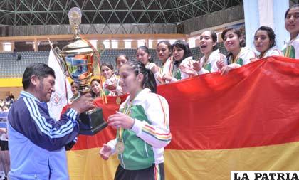 La capitana de la selección de Oruro, Anahí Ledezma, recibe el trofeo de campeón