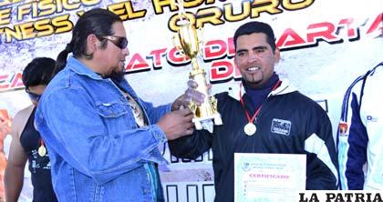 Roger Cabrera recibe el trofeo que lo acredita como el hombre más fuerte de Oruro