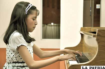 La niña Luz Pinto en la interpretación del piano
