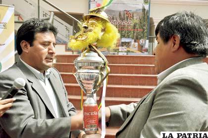 El secretario General del Gador, Edgar Soliz, entrega el trofeo a los ganadores del festival de la Morenada