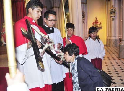 Católicos adoran la cruz en señal de victoria