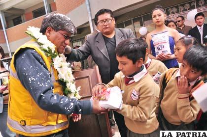 El alcalde entregando el kilo de leche a un niño del “Nacional Andino”