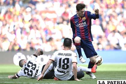 Messi intenta eludir la marca de sus adversarios