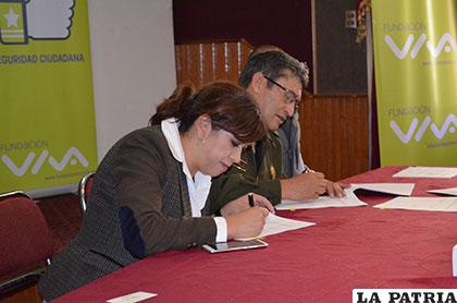 La gerente de la Fundación Viva y el comandante de la Policía firmando el convenio