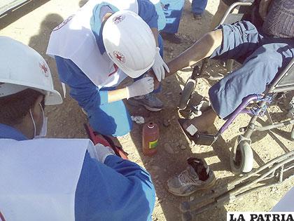 Integrantes de la Cruz Roja dando curando las heridas de los discapacitados