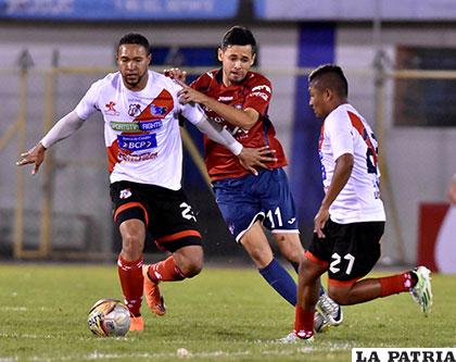 Rojas intenta tener la pelota ante la marca de Tobar y Gallegos /APG