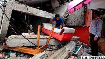 Ecuatorianos sacan algunas pertenencias de entre los escombros tras el terremoto