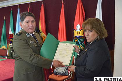El director de la Felcc, teniente coronel Iván Luizaga, entregando un reconocimiento a la fiscal departamental Dubeysa Palacios