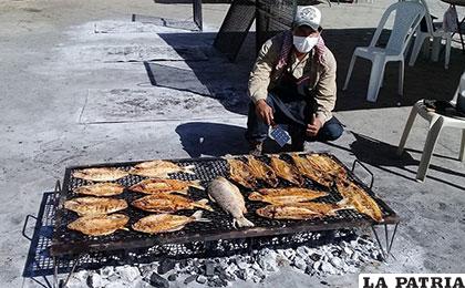 Uno de los asadores muestra el preparado de pescado