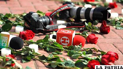 Cámaras y micrófonos de diferentes medios junto a rosas, en señal de rechazo al triple asesinato /zonacero.com