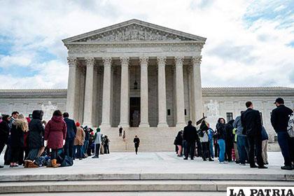 Varias personas esperan en el exterior del Tribunal Supremo en Washington D.C.