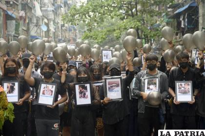 Manifestantes que se oponen al golpe de Estado muestran fotografías de personas que murieron durante una manifestación en contra de las fuerzas militares /AP Foto