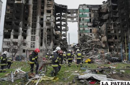 Trabajadores de emergencia cargan escombros de un inmueble destruido en un ataque aéreo ruso al inicio de la guerra en Ucrania /AP Foto /Efrem Lukatsky
