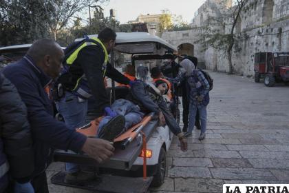 Palestinos evacúan a un hombre herido durante enfrentamientos con las fuerzas de seguridad israelíes en el exterior de la mezquita /AP Foto /Mahmoud Illean