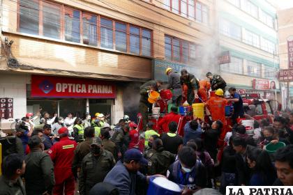 Varias personas ayudan a sofocar el fuego