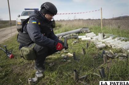 Un zapador del Servicio de Emergencia del Estado ucraniano recoge restos de obuses, granadas y otros artefactos /AP Foto /Andrii Marienko