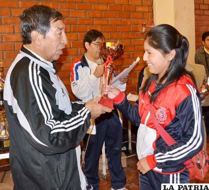 Roberto Medrano entrega el trofeo de campeón a Valeria Villarroel de Edeco