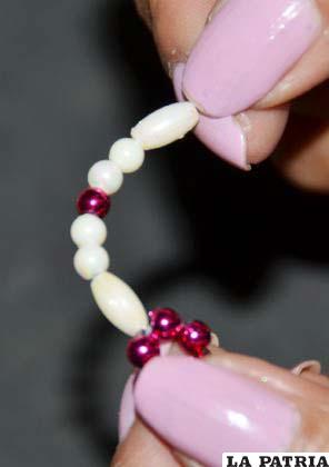 PASO 2
Insertar un arroz, dos perlas marfil, una perla fucsia, dos perlas marfil y un arroz entrando por el lado opuesto del que hemos salido, formando un círculo. Repetir el paso hasta formar todos los pétalos de la flor.
