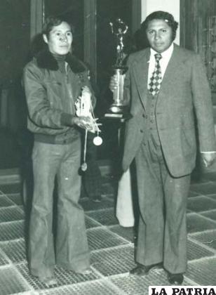El colega José Luis Velásquez y el Prof. Rodolfo Barrientos, con los trofeos ganados por el equipo en la disciplina del voleibol
