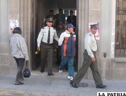 El profesor es escoltado por policías después de la audiencia cautelar