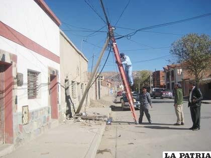 El poste que fue derribado es tratado de ser arreglado por trabajadores de Coteor