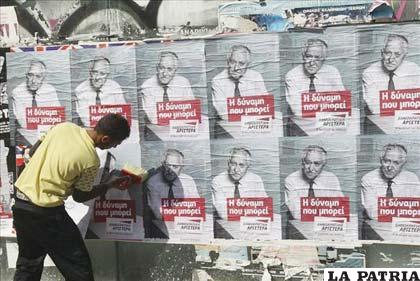 Un trabajador coloca carteles electorales del partido Movimiento Democrático (DIKI) en Atenas (Grecia) (Foto: EFE)