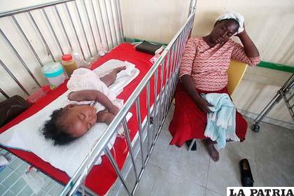 Una mujer cuida a su hija con síntomas de cólera