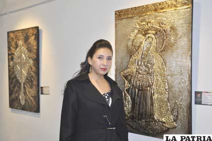 La artista, Carla Rojas, junto a una de sus obras