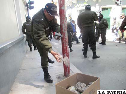 Un efectivo policial recolecta piedras lanzadas por los mineros