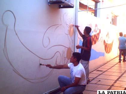 Wilson Zambrana pintando los murales en el Hospital del Niño