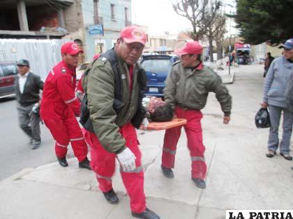 Voluntarios de Bomberos trasladan a uno de los heridos al hospital