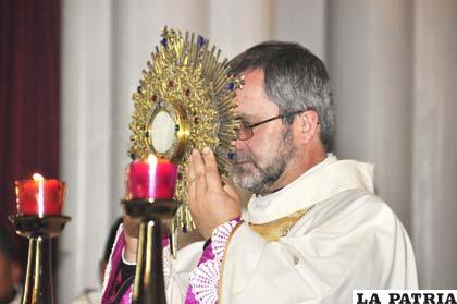 Monseñor Bialasik elevando la custodia donde se encuentra la Hostia Consagrada